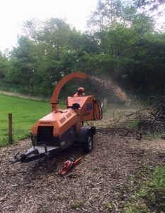 orange grinder firing out tree cuttings