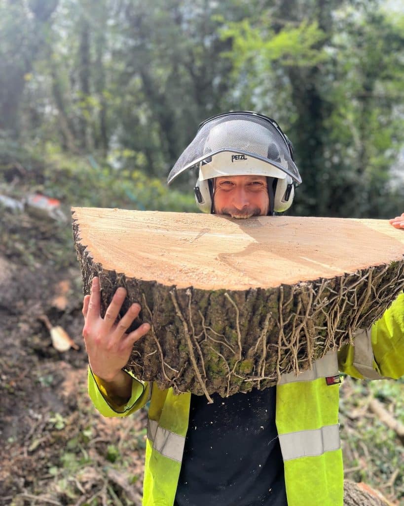 tree surgeon carrying log